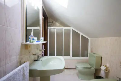 a bathroom with a sink and a toilet and a mirror at Pazo do Vilar in Padrón
