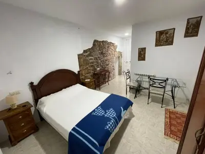 a bedroom with a bed and a table and chairs at Hotel Rural El Nuevo Semellon Aceptamos Mascotas in La Llama