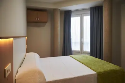 a bedroom with a large bed with a window at Pensión CasaBlanca in Arzúa