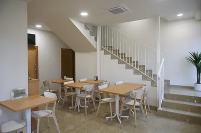 a room with tables and chairs and a staircase at Pensión CasaBlanca in Arzúa