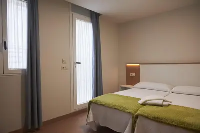 a bedroom with a bed with a green blanket at Pensión CasaBlanca in Arzúa