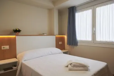 a bedroom with a bed with a towel on it at Pensión CasaBlanca in Arzúa