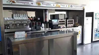 a restaurant kitchen with a counter top and appliances at Albergue Ferramenteiro in Portomarin
