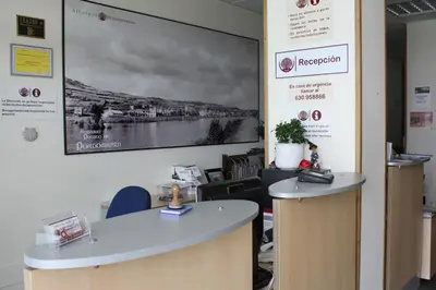 an office with two reception desks and a large screen at Albergue Ferramenteiro in Portomarin