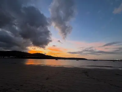 a sunset on the beach with a cloudy sky at Ático a 5 minutos de TODO Mariña Lucense in Viveiro