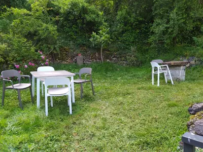 a group of tables and chairs in the grass at Casa Pipa in Pola de Somiedo