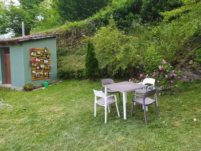 a table and chairs in the grass in a yard at Casa Pipa in Pola de Somiedo