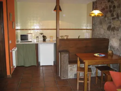 a small kitchen with a table and a microwave at Casa Pipa in Pola de Somiedo