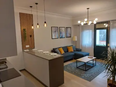 a living room with a blue couch and a table at Apartamento Puerta de San Fernando in Lugo