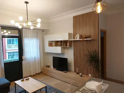 a living room with a tv and a table at Apartamento Puerta de San Fernando in Lugo