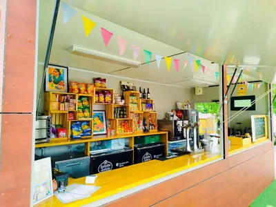 a store with a store front with flags on the ceiling at O Pedrouzo Pilgrim Camp in O Pedrouzo