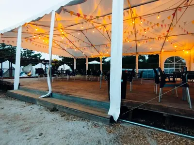 a tent with lights and chairs under it at O Pedrouzo Pilgrim Camp in O Pedrouzo