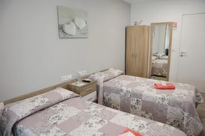 a room with two beds and a mirror at Apartamento Camiño Real 2 - A Casa de María 2ª Planta in Sigüeiro