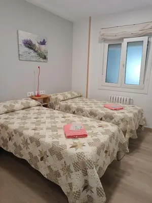 a room with two beds and a window at Apartamento Camiño Real 2 - A Casa de María 2ª Planta in Sigüeiro