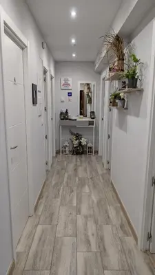 a hallway with white walls and wooden flooring at Apartamento Camiño Real 2 - A Casa de María 2ª Planta in Sigüeiro