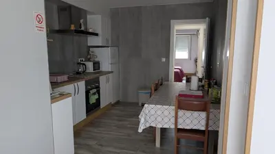 a kitchen with a table with chairs and a counter top at Apartamento Camiño Real 2 - A Casa de María 2ª Planta in Sigüeiro