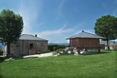 a barn and a building in a field at Apartamentos rurales Casa Do Cabo in Vega de Logares