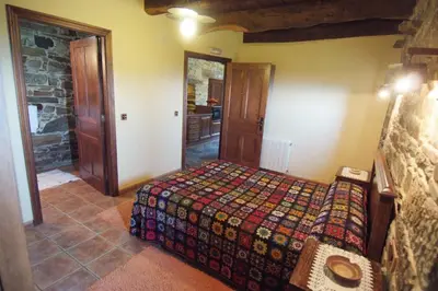 a bedroom with a bed in a room at Apartamentos rurales Casa Do Cabo in Vega de Logares
