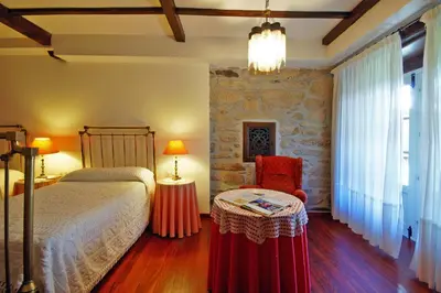 a bedroom with a bed and a table and a chair at Casa Grande De Trives in Puebla de Trives