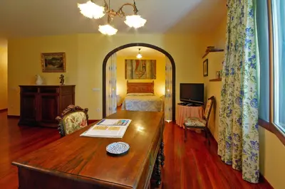 a room with a bedroom with a bed and a table at Casa Grande De Trives in Puebla de Trives