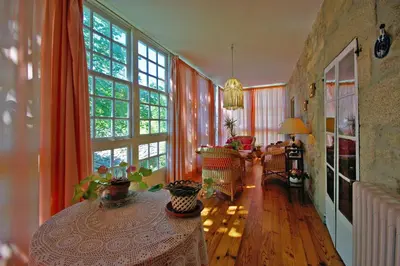 a living room with orange curtains and a table at Casa Grande De Trives in Puebla de Trives