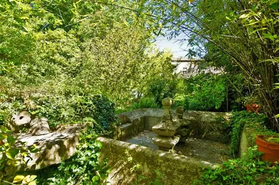 a garden with a fountain in the middle of a yard at Casa Grande De Trives in Puebla de Trives