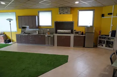 a large kitchen with brown cabinets and a green floor at Casa Ribeira Sacra in Chantada
