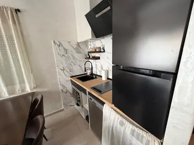 a kitchen with a black refrigerator and a sink at O descanso do Peregrino in Sarria