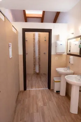 a bathroom with two sinks and two toilets at Miraz Albergue O Abrigo