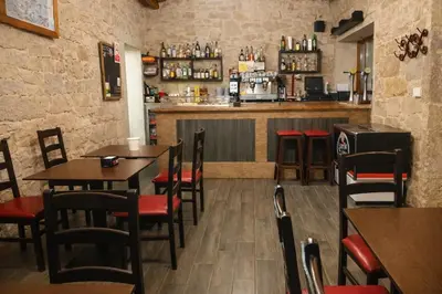 a restaurant with tables and chairs and a bar at Miraz Albergue O Abrigo