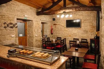 a restaurant with a counter with bread on it at Miraz Albergue O Abrigo