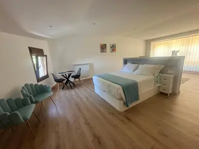 a bedroom with a bed and a table and chairs at A Casa do Veterinario 1 in Boqueijón