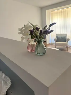 a vase filled with flowers sitting on a counter at A Casa do Veterinario 1 in Boqueijón