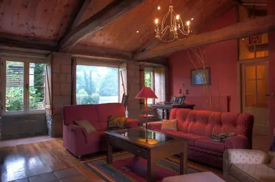 a living room with red furniture and a chandelier at Casa de Arias in Parga