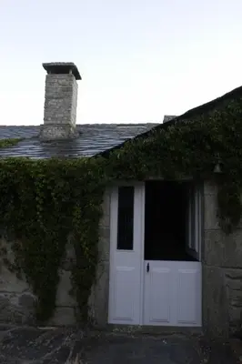 a white door on a stone house with ivy at Casa de Arias in Parga