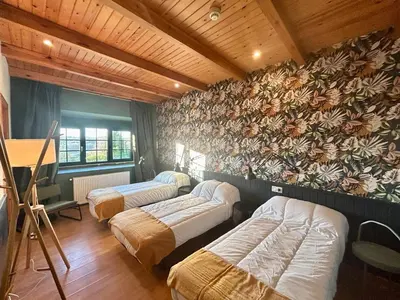 a room with a table and chairs and a wall at Casa Bolboreta by Unusual Hotels in Palas de Rei