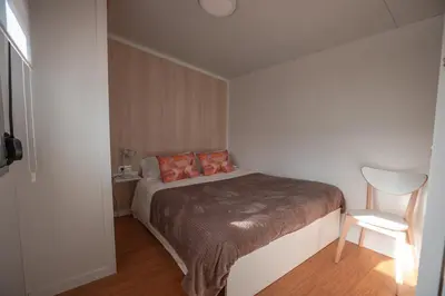 a bedroom with a bed with orange pillows and a chair at Balea House in Barreiros