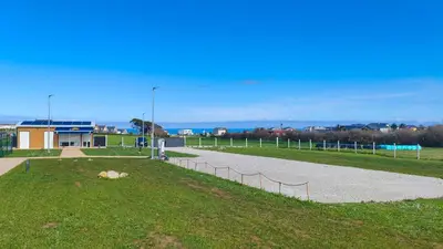 a path in a park with a field and a building at Balea House in Barreiros
