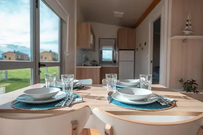 a table with plates and glasses on top of it at Balea House in Barreiros
