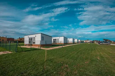 a row of houses on a grass field with a car at Balea House in Barreiros