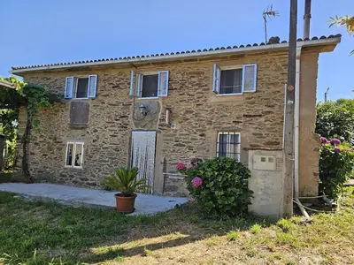 an old stone house with a garden at Villa Tojo in Touro