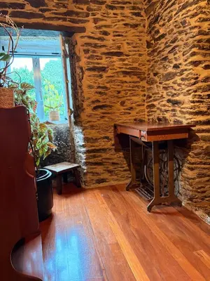 a piano in a room with a stone wall at Villa Tojo in Touro