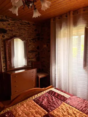 a bedroom with a bed and a dresser and a window at Villa Tojo in Touro