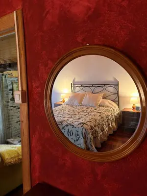 a bedroom with a mirror in a red wall at Villa Tojo in Touro