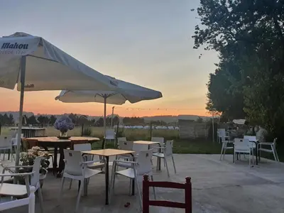 a group of tables and chairs with an umbrella at La pallota de san Cristóbal in Camino