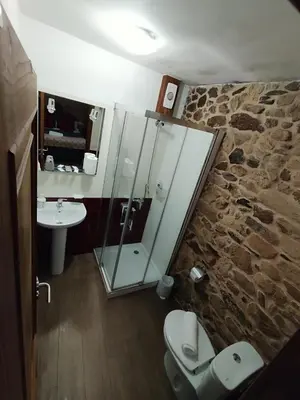 a bathroom with a glass shower and a sink at La pallota de san Cristóbal in Camino