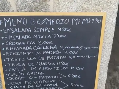 a chalk board with a menu for a restaurant at La pallota de san Cristóbal in Camino