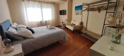 a bedroom with a bed and a chair and a window at Piso muy luminoso y céntrico 1D in Santiago de Compostela