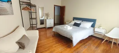 a bedroom with a bed and a chair and a ladder at Piso muy luminoso y céntrico 1D in Santiago de Compostela