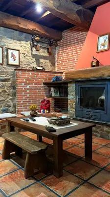 a room with a wooden table and a tv at Casa Rural Dorinda in Campelo